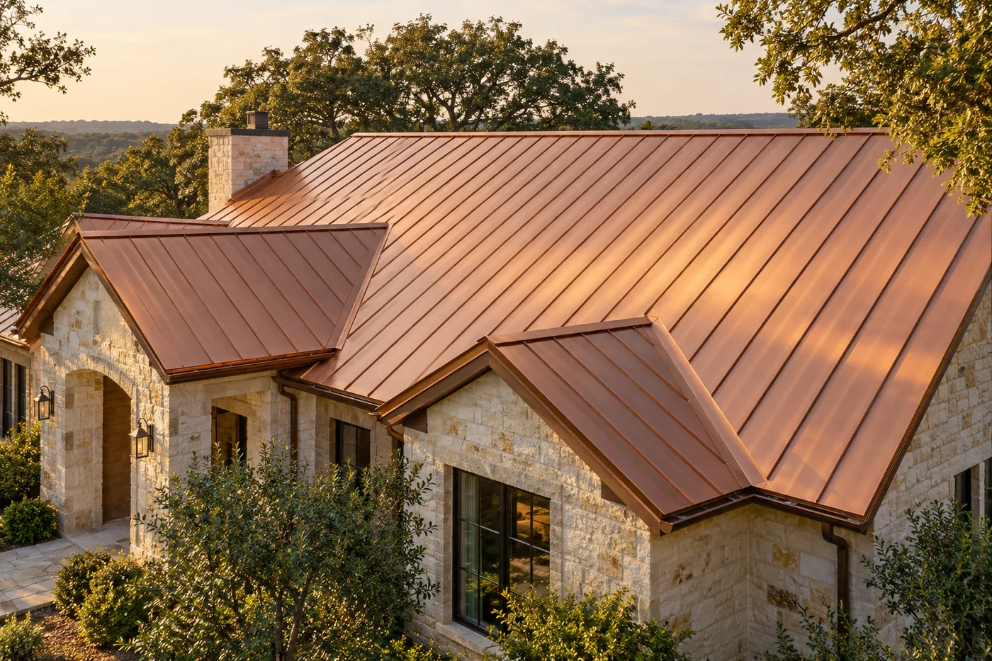 Copper standing seam roof across a limestone home with gabled roof sections